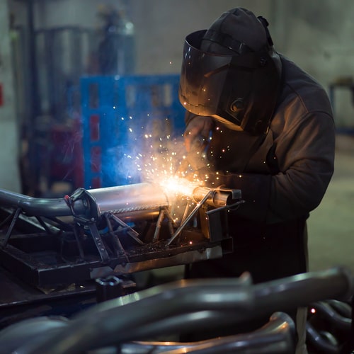 worker-welding-exhaust-pipes-pieces-together-2023-11-27-05-31-36-utc (1)-min